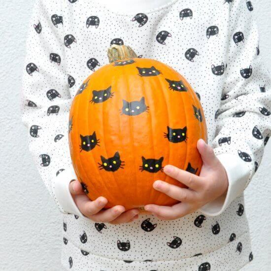 a simple and classic black cat pumpkin decorated with a usual sharpie will be a nice idea to craft with your kids