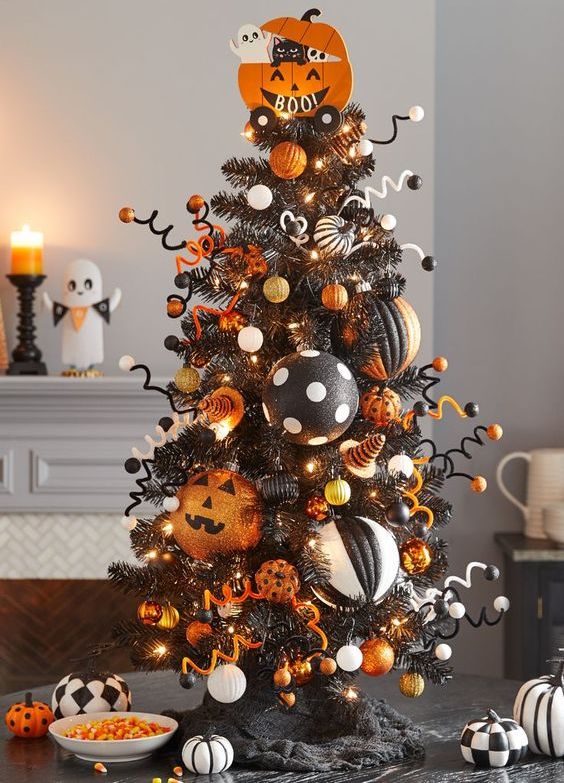 a black Halloween tree with white, gold, orange and black and white ornaments, lights, wire and balls is amazing