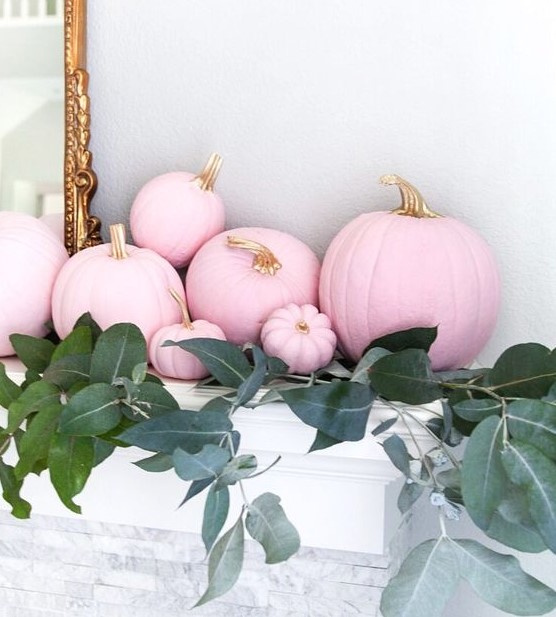 pink pumpkins with gold stems and greenery on the mantel for a lovely and glam Halloween mantel is amazing