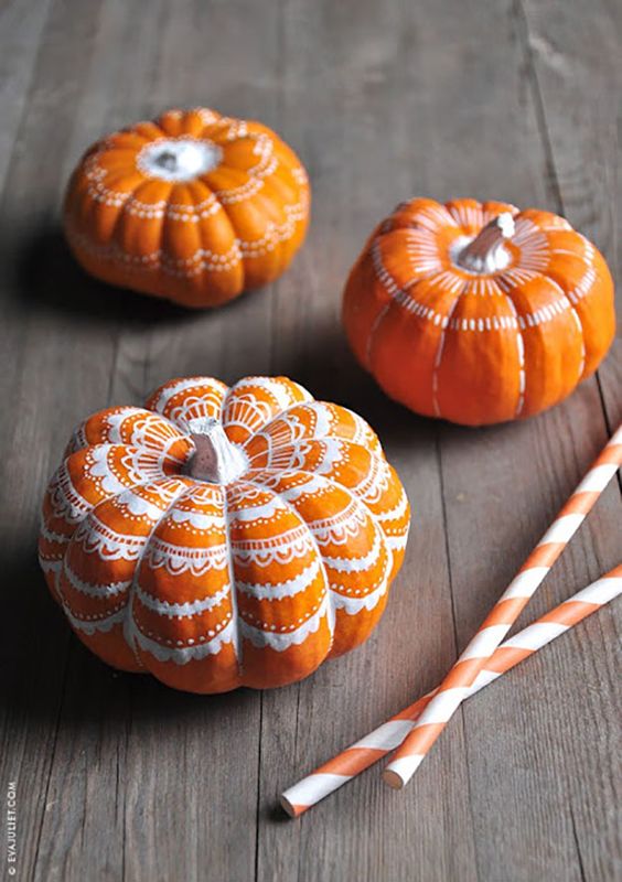 classic orange pumpkins decorated with a white sharpie with some lace patterns look very chic, nice and fun and can be easily DIYed