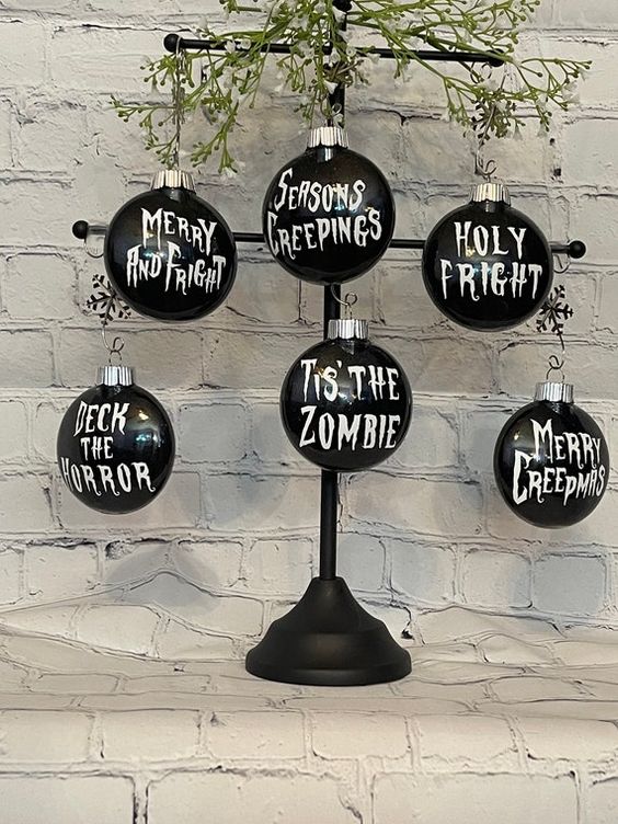 a metal Halloween tree with greenery and black ornaments with white letters - you can DIY some for your tree