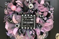 19 a fun black, pink and white Halloween wreath with lots of mesh ribbons and striped ones, ornaments, donuts and a sign