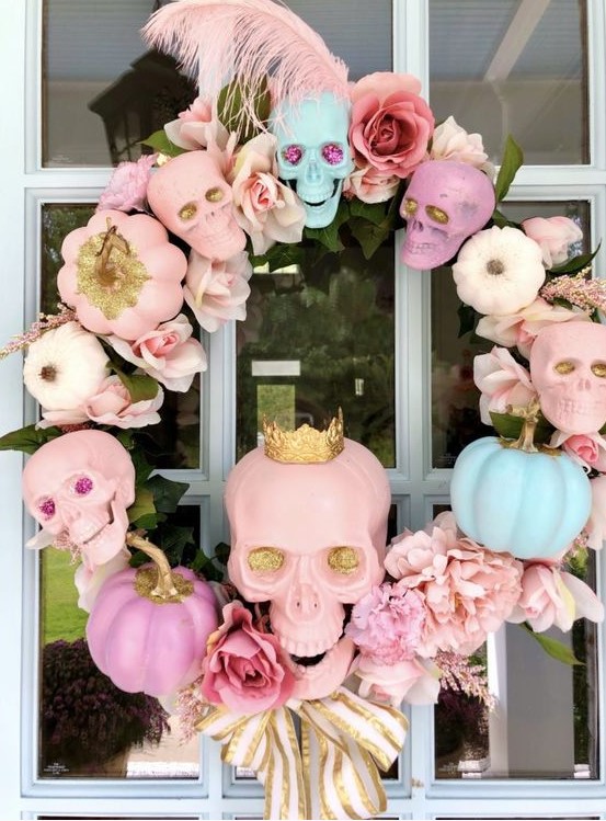a lovely pastel skull, pumpkin and bloom wreath with feathers, ribbon bows and leaves for Halloween