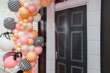 24 a pink, orange, yellow and striped balloon garland with giant spiders and bats is a gorgeous solution for Halloween