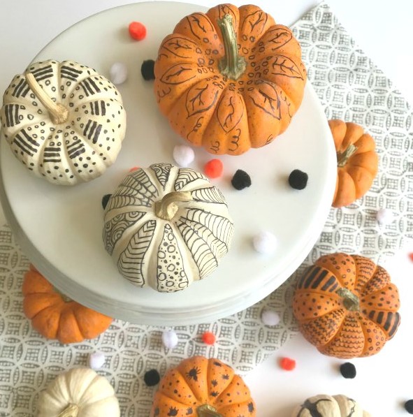 white and orange pumpkins decorated with a black sharpie are a nice solution for Halloween and for the fall, too