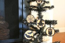 28 a black Halloween tree with round ornaments that show off bats, cats, skulls, spiderwebs is a very fun and creative idea
