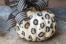 28 a leopard pumpkin decorated with simple sharpies, with a bit of gold glitter on top and a striped bow is a cool and bold idea for Halloween