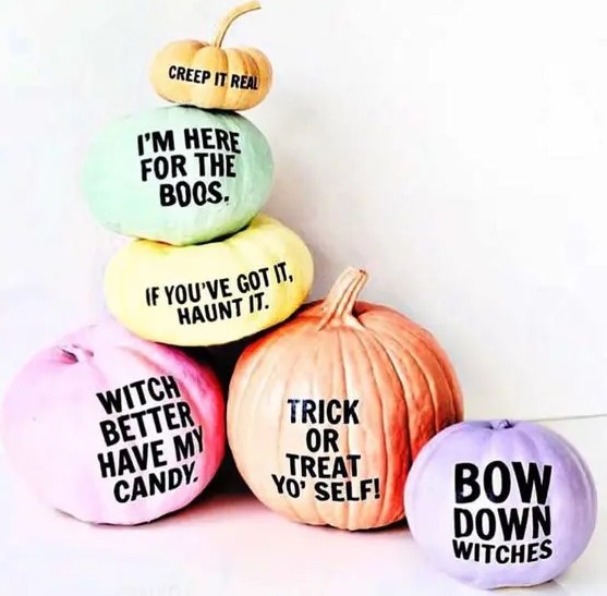 an arrangement of Halloween pumpkins with fun and quirky phrases on them for a modern touch