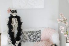 28 glam entryway decor with pink and black velvet pumpkins, a pink blanket and a skeleton dressed up in a glam way