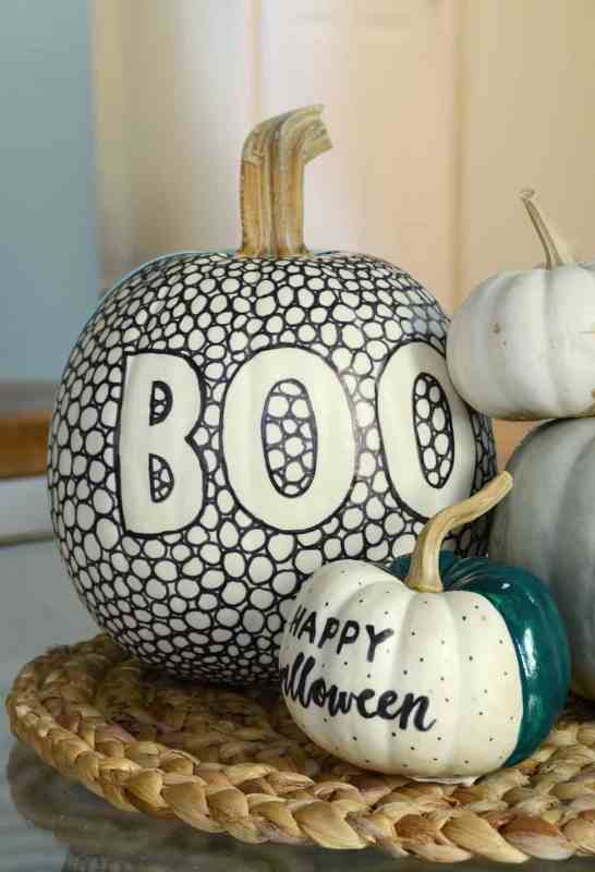 a super cool black and white pumpkin made with a sharpie and a green, black and white one made using a sharpie and some paint