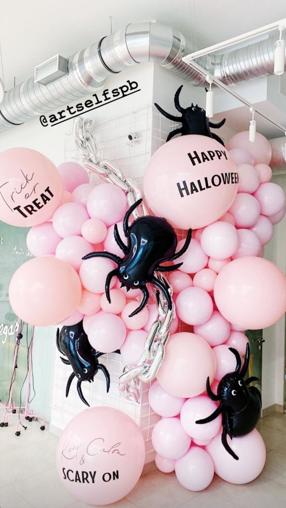 jaw-dropping Halloween decor with pink ballons, oversized black spider balloons, chains is fantastic for a party