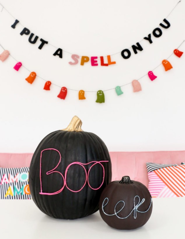 black pumpkins decorated with neon wire letters look bold, modern and super cool and will match your modern and bright Halloween party