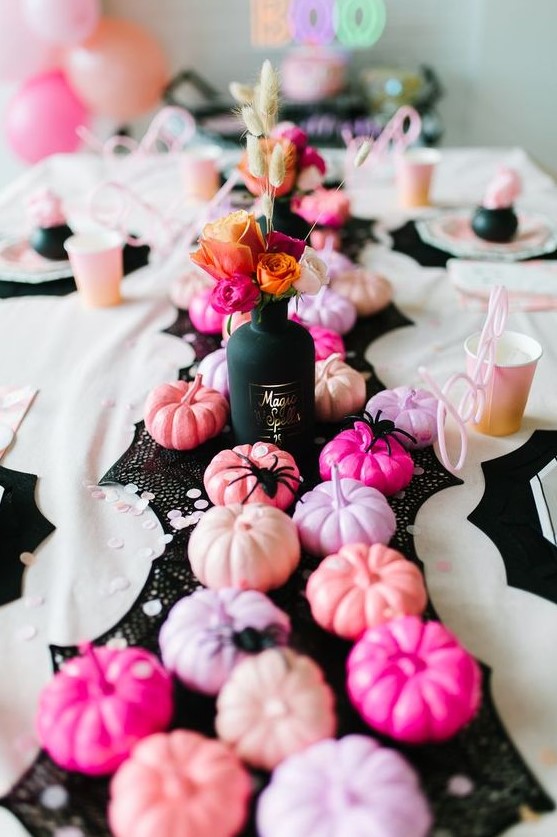 super glam Halloween table decor with a black runner, pink, blush, lilac and hot pink pumpkins and bold blooms