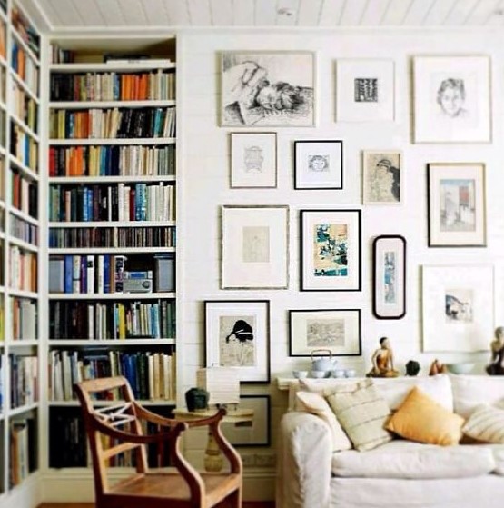 a beautiful free form gallery wall with thin black and silver frames and black and white and colored art