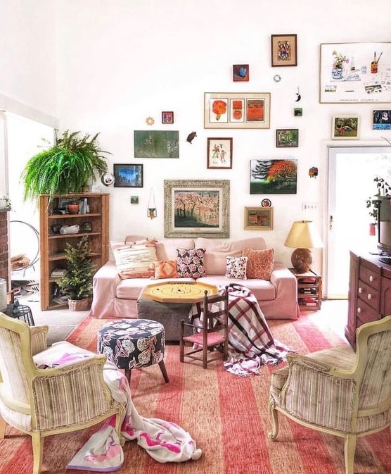 a bright eclectic gallery wall with mismatching frames climbing up the wall and going over the doorway is a very creative idea