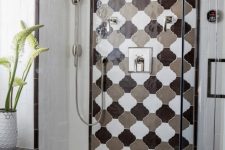 a bright shower space clad with geometric tiles and a bold monochromatic arabesque tile accent is super cool