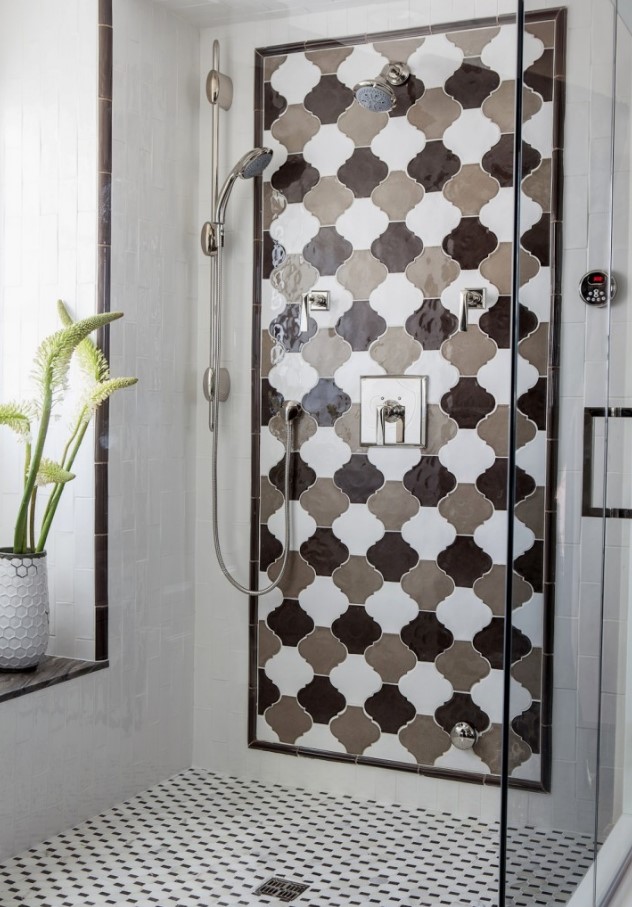 a bright shower space clad with geometric tiles and a bold monochromatic arabesque tile accent is super cool