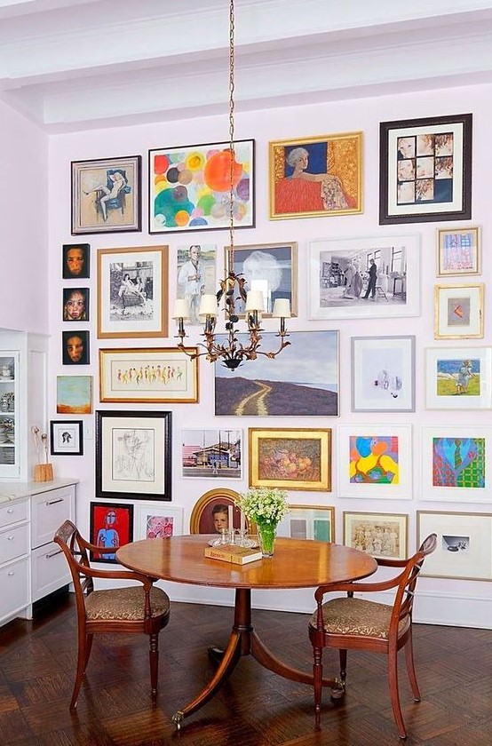 a colorful gallery wall with mismatching vintage frames, with and without mats, with art in various bright colors
