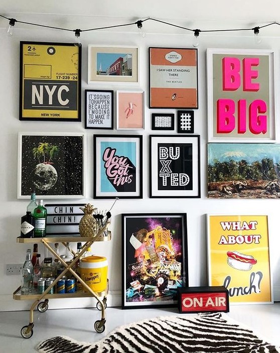 a colorful pop art gallery wall in various colors - posters for fun and with black and white frames is a bold idea