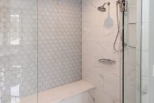 a fantastic shower space clad with white marble, penny and arabesque tiles, with a bench is a gorgeous idea for a refined modern bathroom