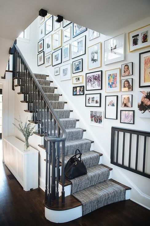 a free form gallery wall with mismatching frames and bold and black and white artworks and family pics is a cool idea