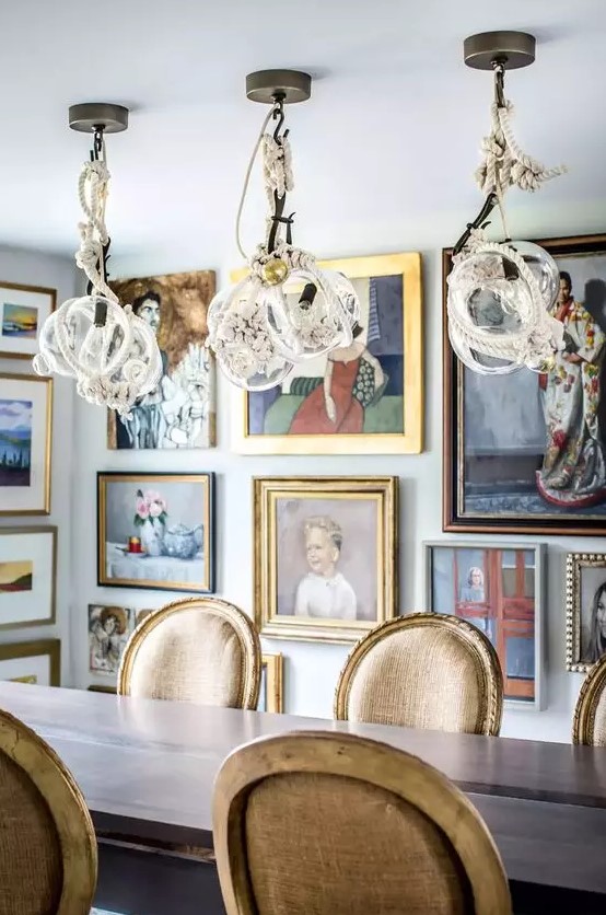 a jaw-dropping dining room with a simple table and vintage chairs, whimsical rope pendant lamps and artworks all over the space