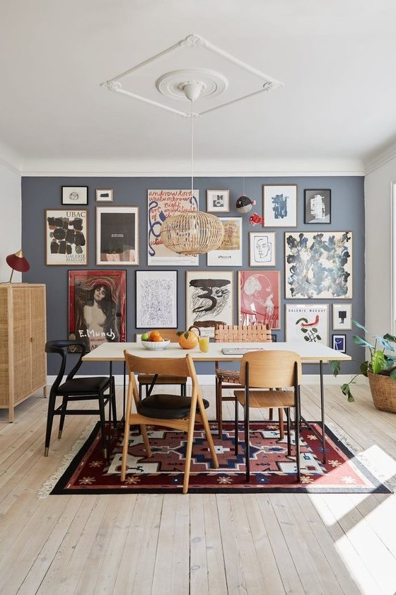 a large and bold free form gallery wall with thin frames and colorful art, mostly abstract, takes over the whole space