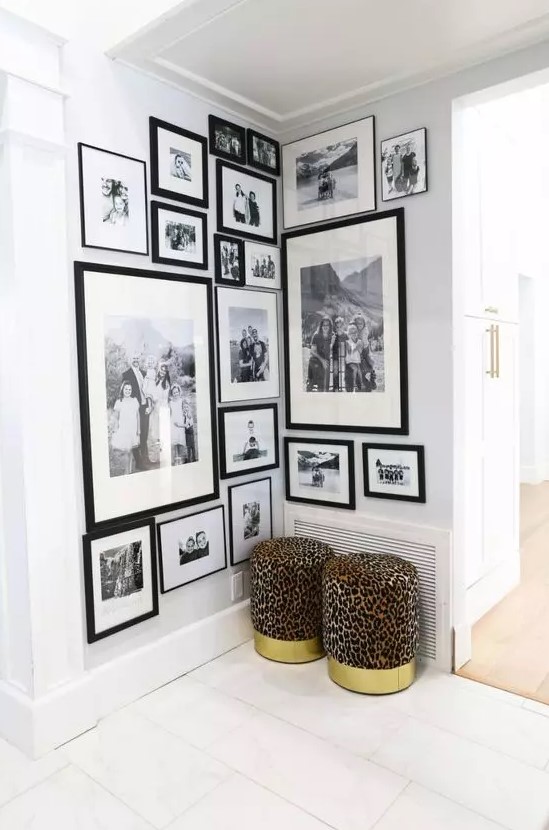 a large corner gallery wall of black and white family photos in matching black frames is a good idea to style an awkward nook