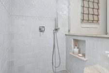 a large shower space done with blue arabesque and square tiles, with small blue tiles on the floor is a beautiful nook