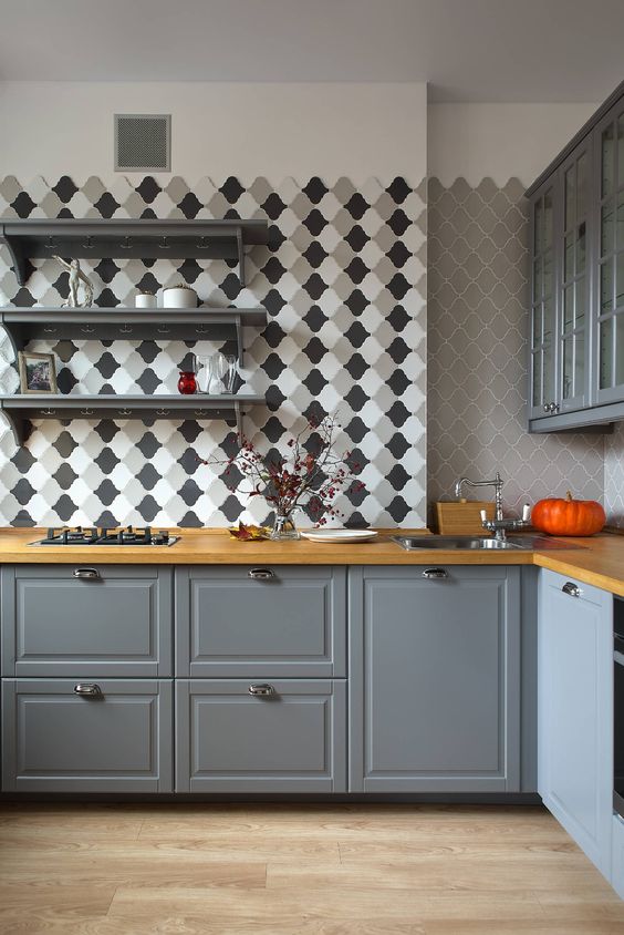 a modern grey kitchen with shaker cabinets, butherblock countertops, an arabesque tile backsplash and open shelves is chic and cool