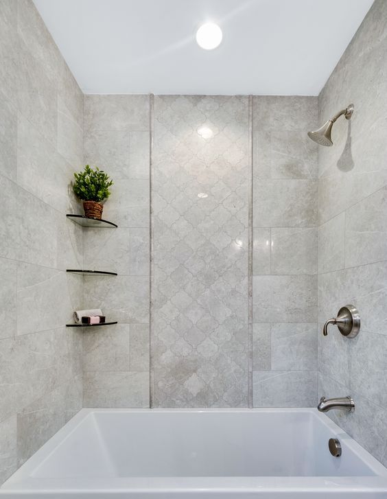 a neutral bathroom with large scale and arabesque tiles, with a square bathtub and corner shelves and vintage fixtures