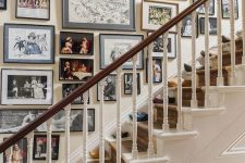 a refined free form gallery wall with mismatching black frames and various types of art – from family photos to paintings
