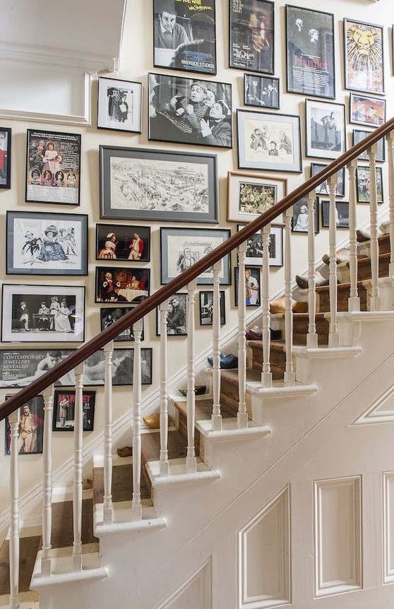 a refined free form gallery wall with mismatching black frames and various types of art - from family photos to paintings