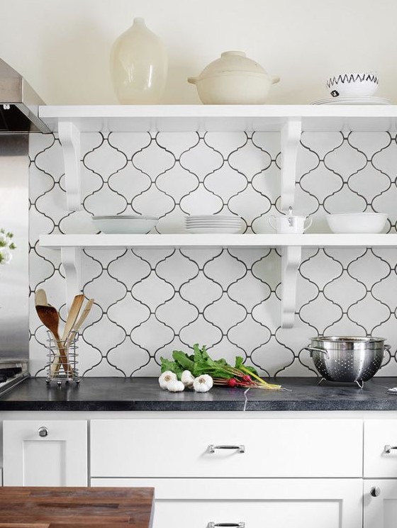 a stylish black and white kitchen, with black countertops and a creative white arabesque tile backsplash is a lovely and chic idea