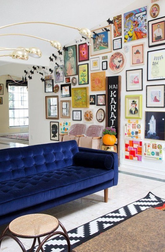 an eclectic and colorful gallery wall with bold paintings, posters, signs, prints and various elements to make it catchier