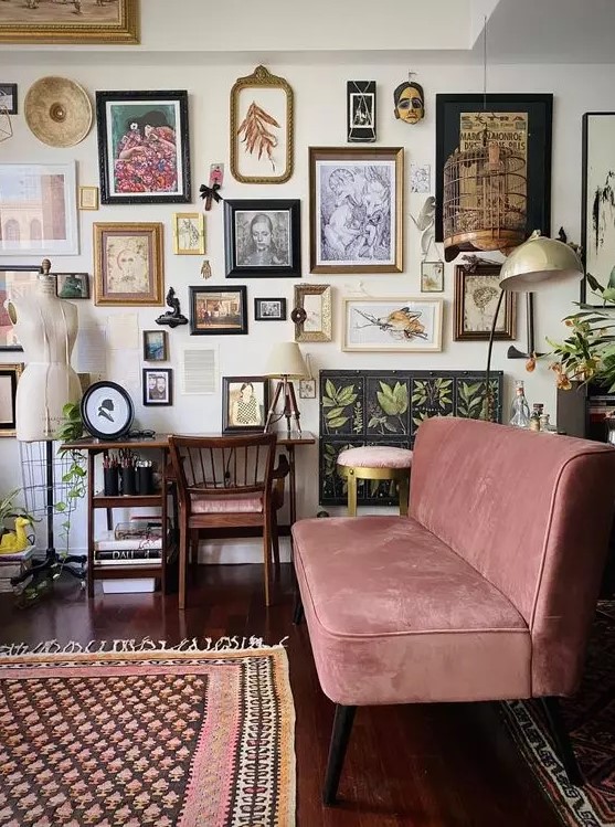 an eclectic living room gallery wall with various artwork, masks, mini sculptures and botanical posters is lovely