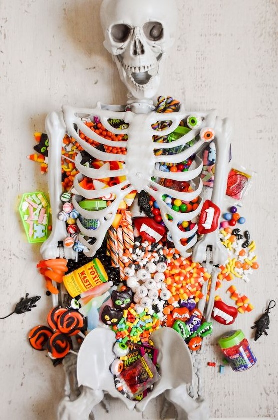 a candy table styled with a skeleton is a perfect solution for Halloween, you can offer sweets to your guests this way