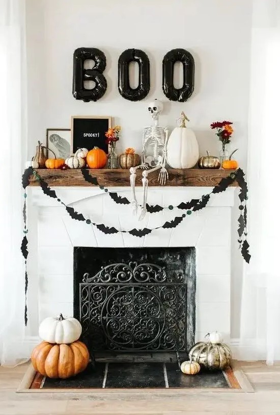 a modern Halloween mantel with a skeleton, balloon letters, buntings, pumpkins and signs