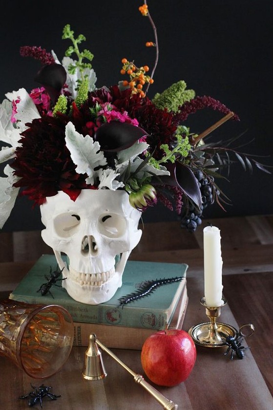 a skull vase with dark dahlias, callas, greenery, berries and some dark foliage is a stunning Halloween centerpiece
