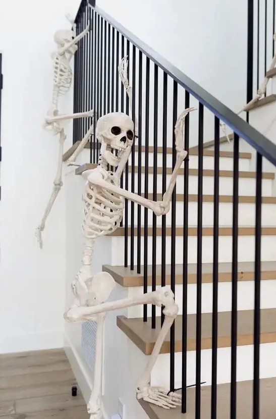 skeletons climbing up the railing are a fun and very easy idea to style your home for Halloween and you can realize that very quickly