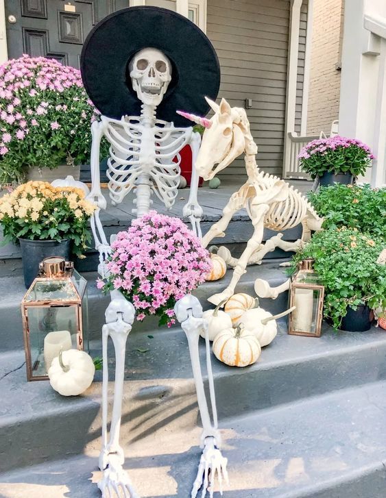 a beautiful and fun Halloween scene with a skeleton and unicorn skeleton, with white pumpkins, lanterns and blooms