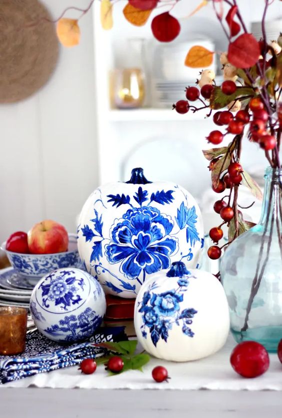 white pumpkins painted with blue and navy blooms inspired by chinoiserie are adorable for vintage fall decor