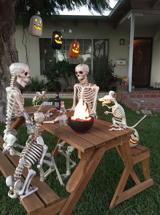a cool outdoor bbq scene done with skeletons and skeleton dogs plus jack-o-lanterns is a very fresh and fun idea