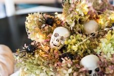 26 a neutral bowl with dried hydrangeas, skulls, lights and white velvet pumpkins for Halloween