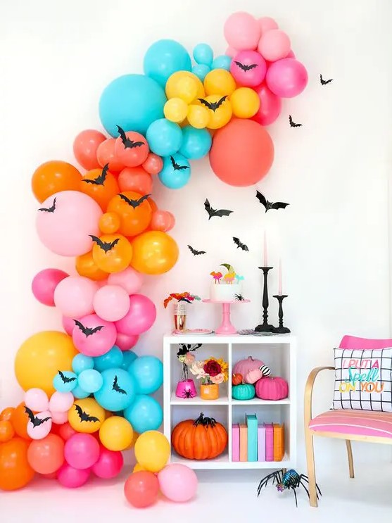 an oversized colorful balloon garland with bats, bright books and pumpkins for Halloween decor