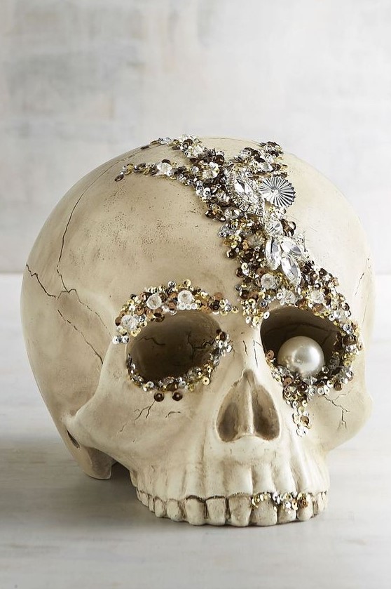 a refined glam Halloween decoration - an embellished skull with rhinestones, sequins and a large pearl as an eye is amazing