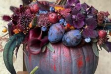 31 a jaw-dropping grey pumpkin decorated with dark burgundy and purple blooms, plums, berries and apples and dried grasses