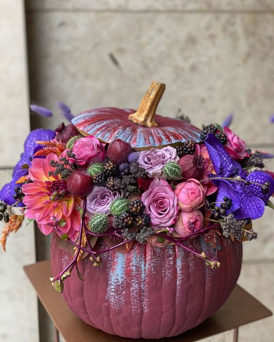 a jaw-dropping purple Halloween pumpkin with pink, mauve and violet blooms, berries and cherries is a chic idea