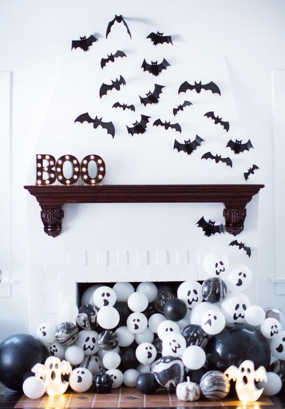 paper bats over the mantel, marquee letters and black and white balloons in the fireplace for Halloween styling