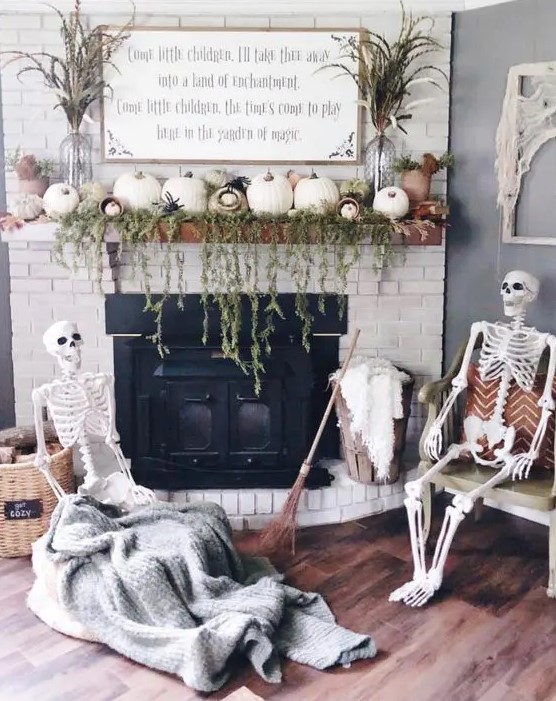 a neutral Halloween fireplace decorated with greenery and white pumpkins, with a skeleton scene in front of it is a cool idea